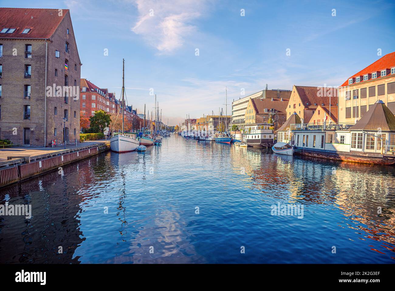 River canal with many boats and ships with small old houses in the  neighbourhood area Christianshavn in Copenhagen, Denmark Stock Photo