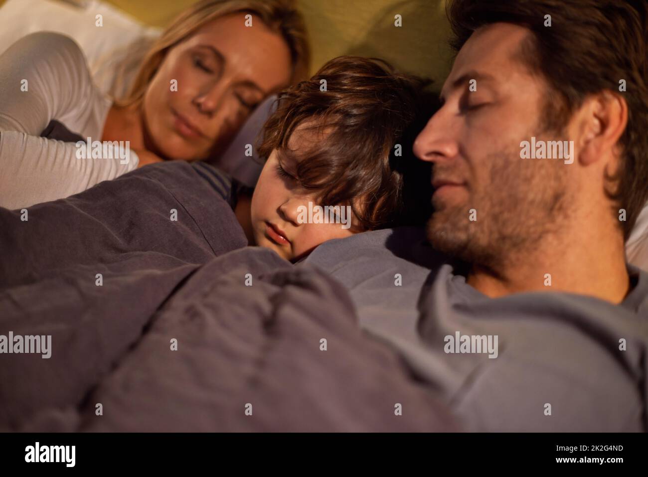 Off to dreamland together. Shot of a young family sleeping beside each other. Stock Photo