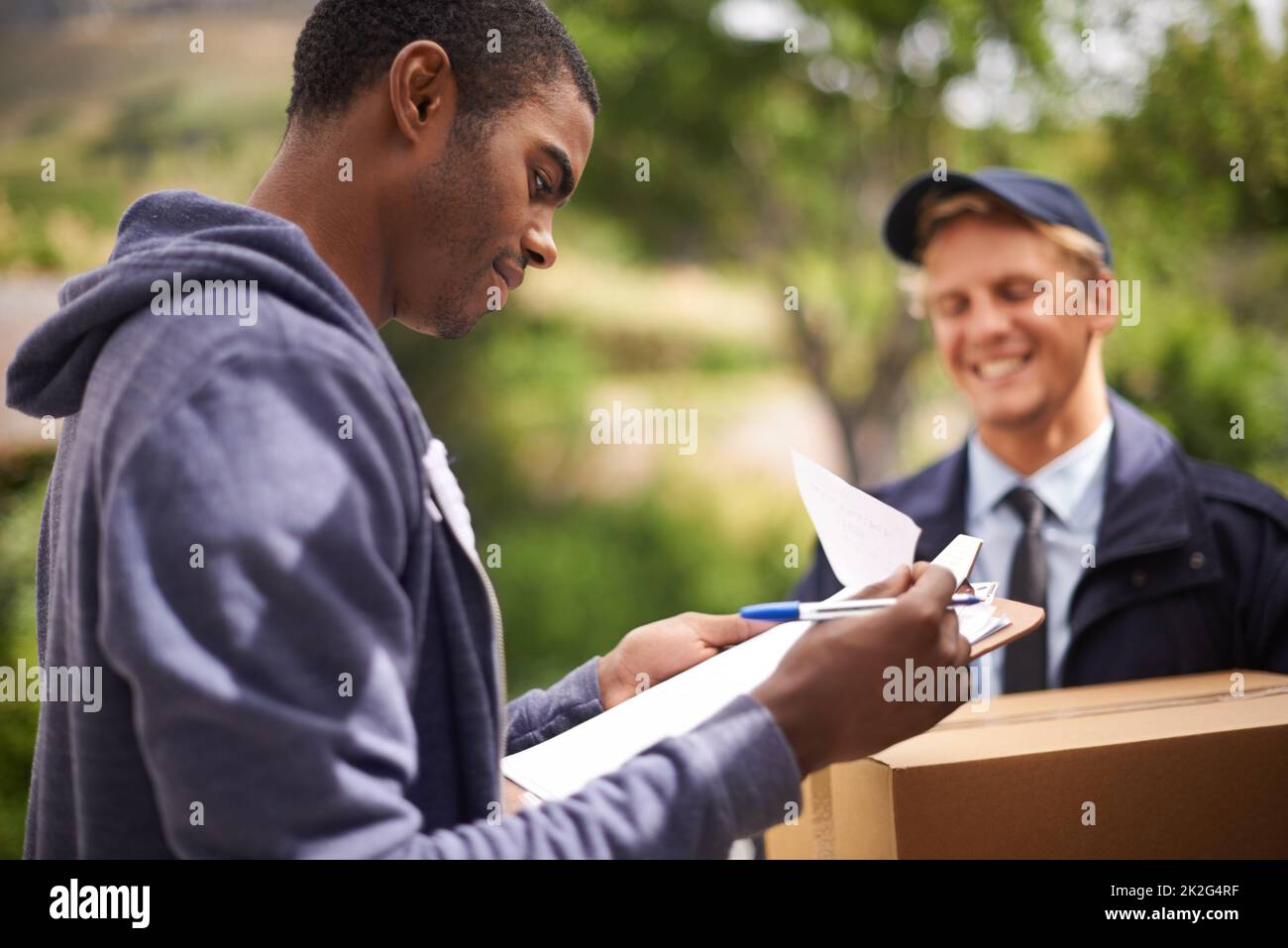Man First Form Checking the fine print. a handsome young man signing a form for a ...