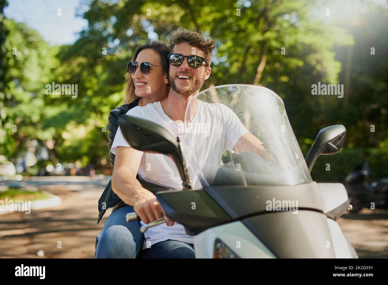 We fell in love with each other while exploring. Cropped shot of a young attractive couple riding a scooter around town. Stock Photo