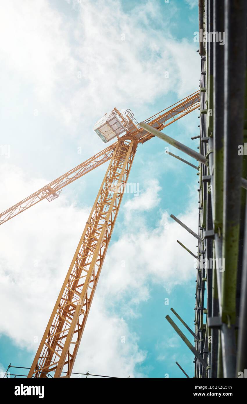 The city isnt just getting bigger, its getting better. Shot of a crane and building at a construction site. Stock Photo