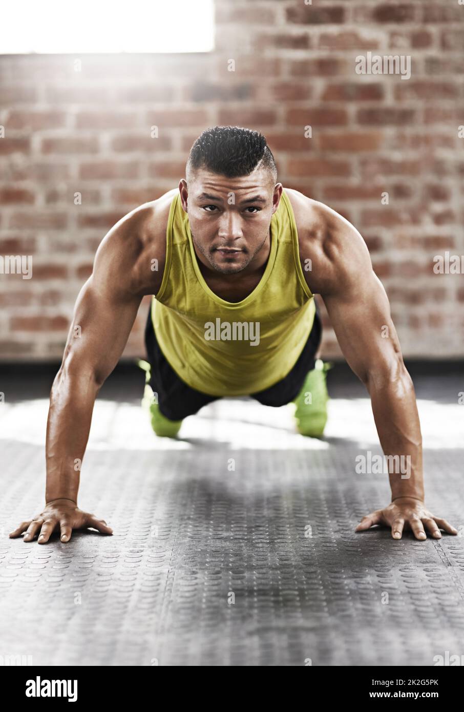 Muscle up. Full length shot of a young man working out in the gym Stock