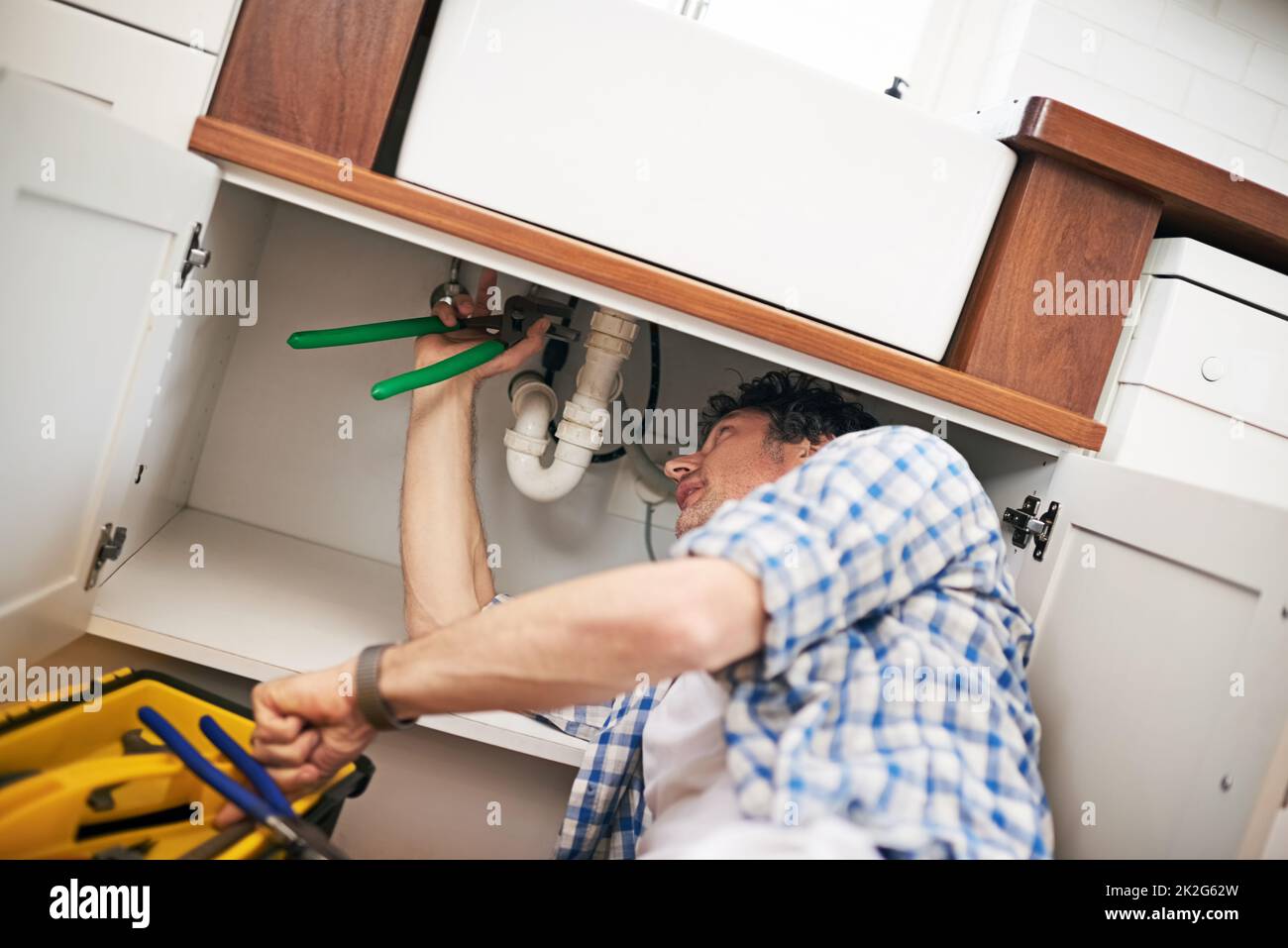I think I see your problem. Shot of a man fixing a pipe under his