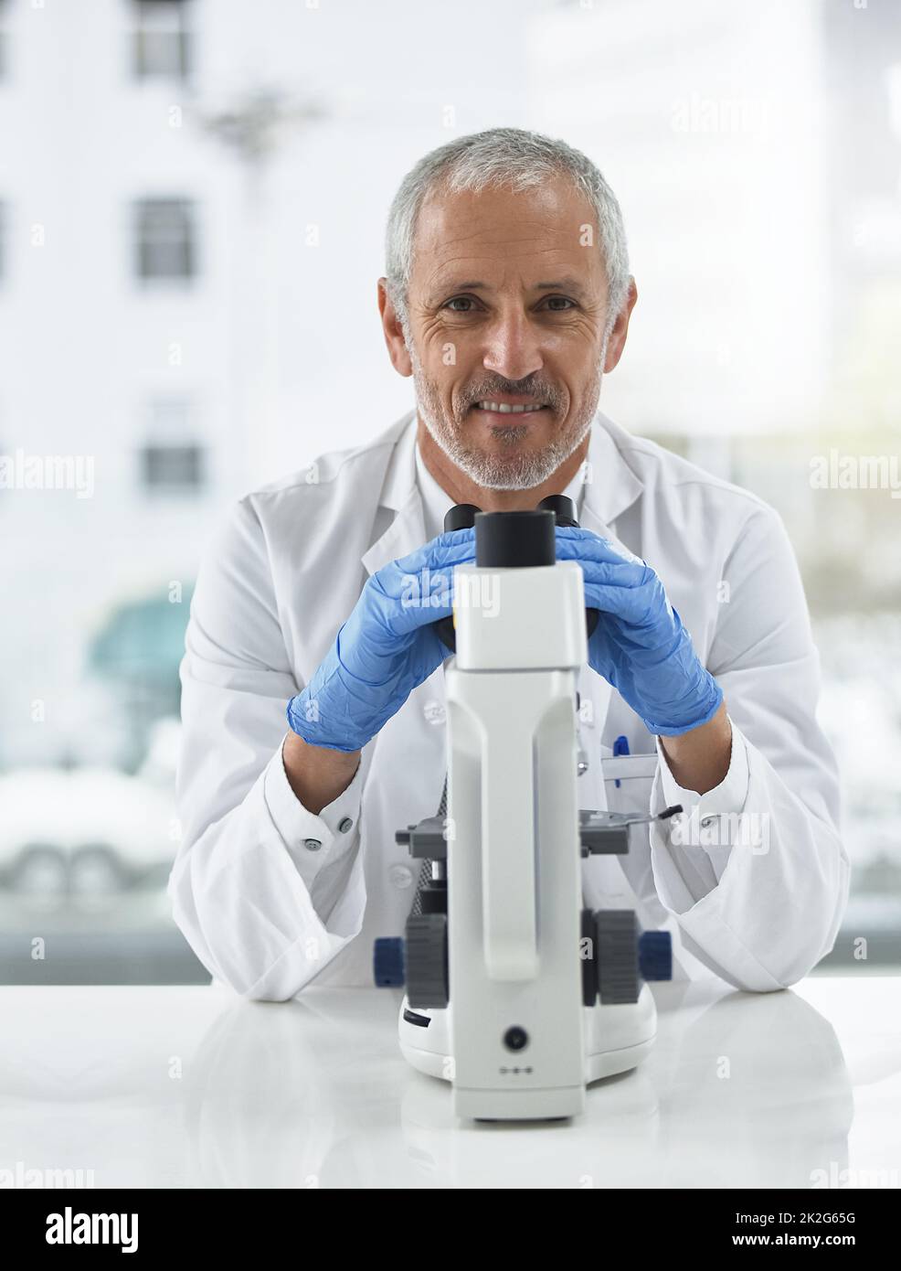 Discovery can be in the smallest details. Portrait of a researcher at work on a microscope in a lab. Stock Photo