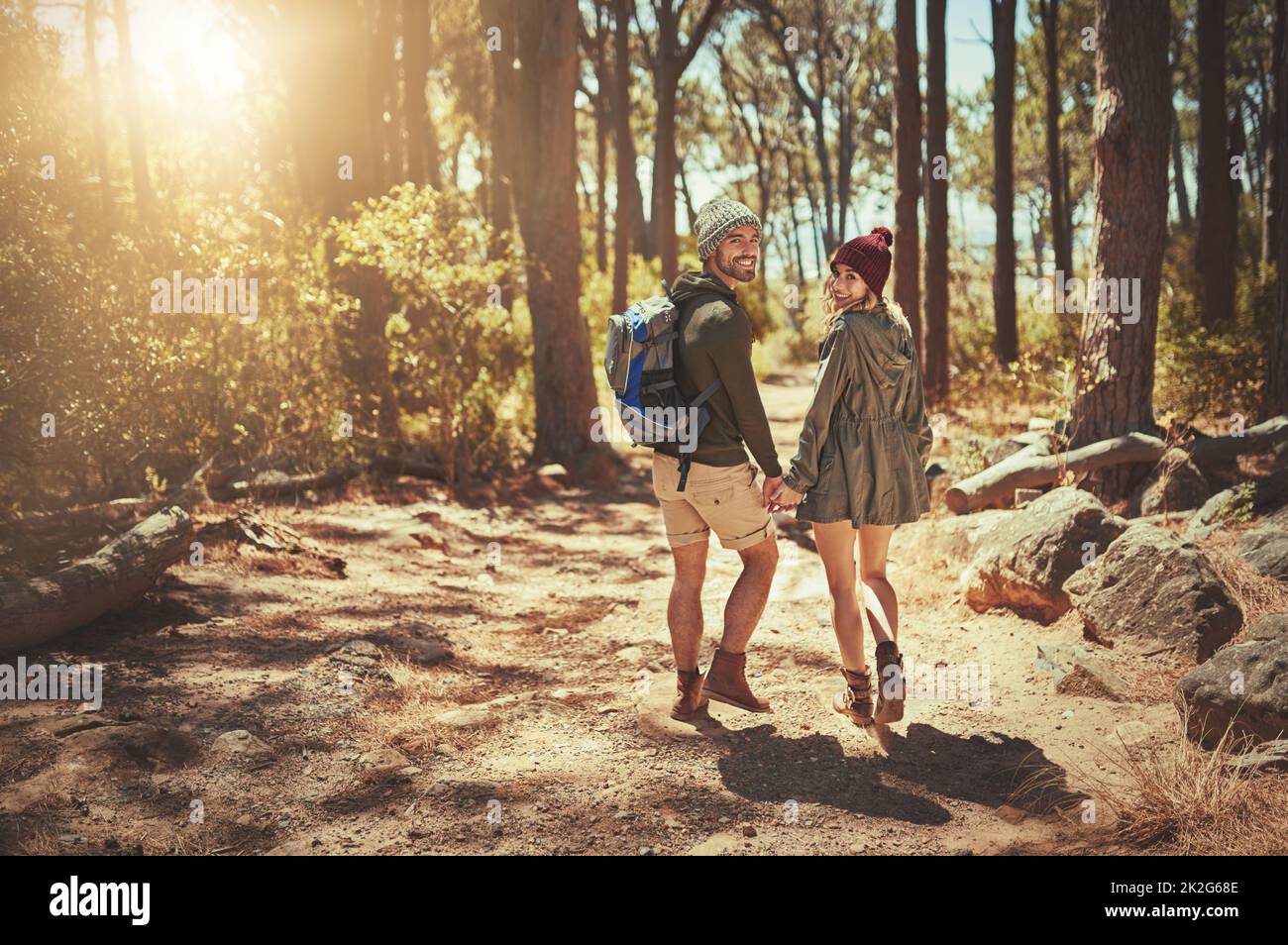 Not all those who wander are lost. Rearview shot of an affectionate young couple hiking. Stock Photo