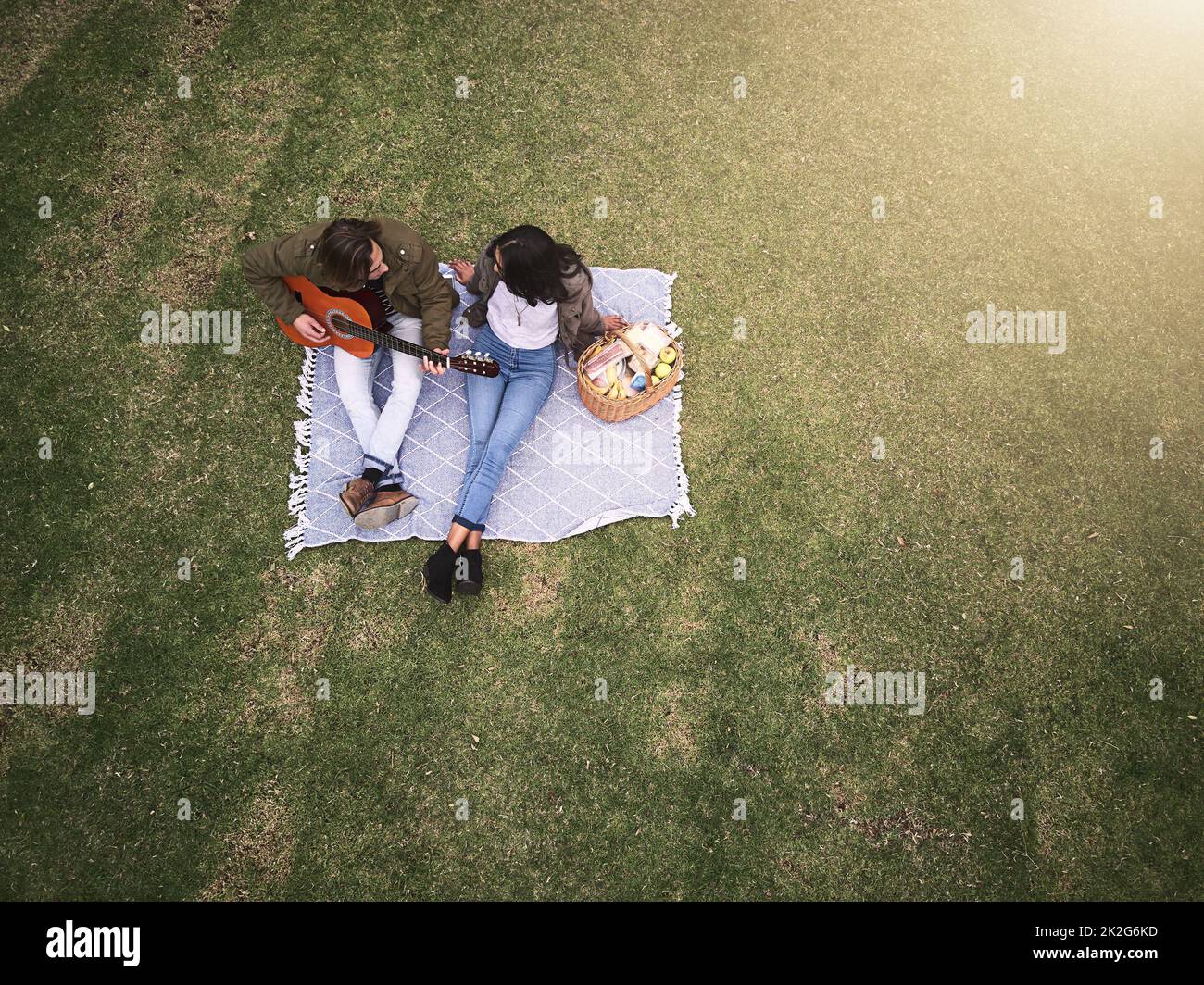 Romance and music in the park. High angle shot of a young couple having a romantic date in the park. Stock Photo