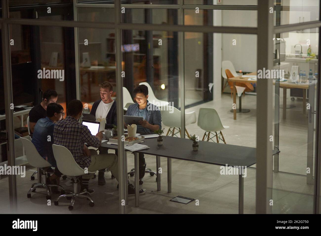 Putting in some extra hours at work. Shot of employees working in an office at night. Stock Photo
