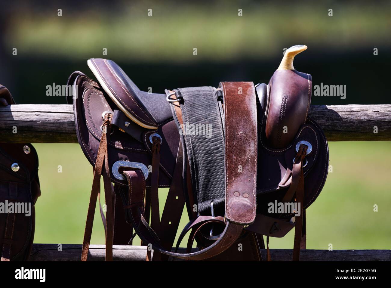 Ready to ride. Cropped shot of a saddle on a fence Stock Photo - Alamy