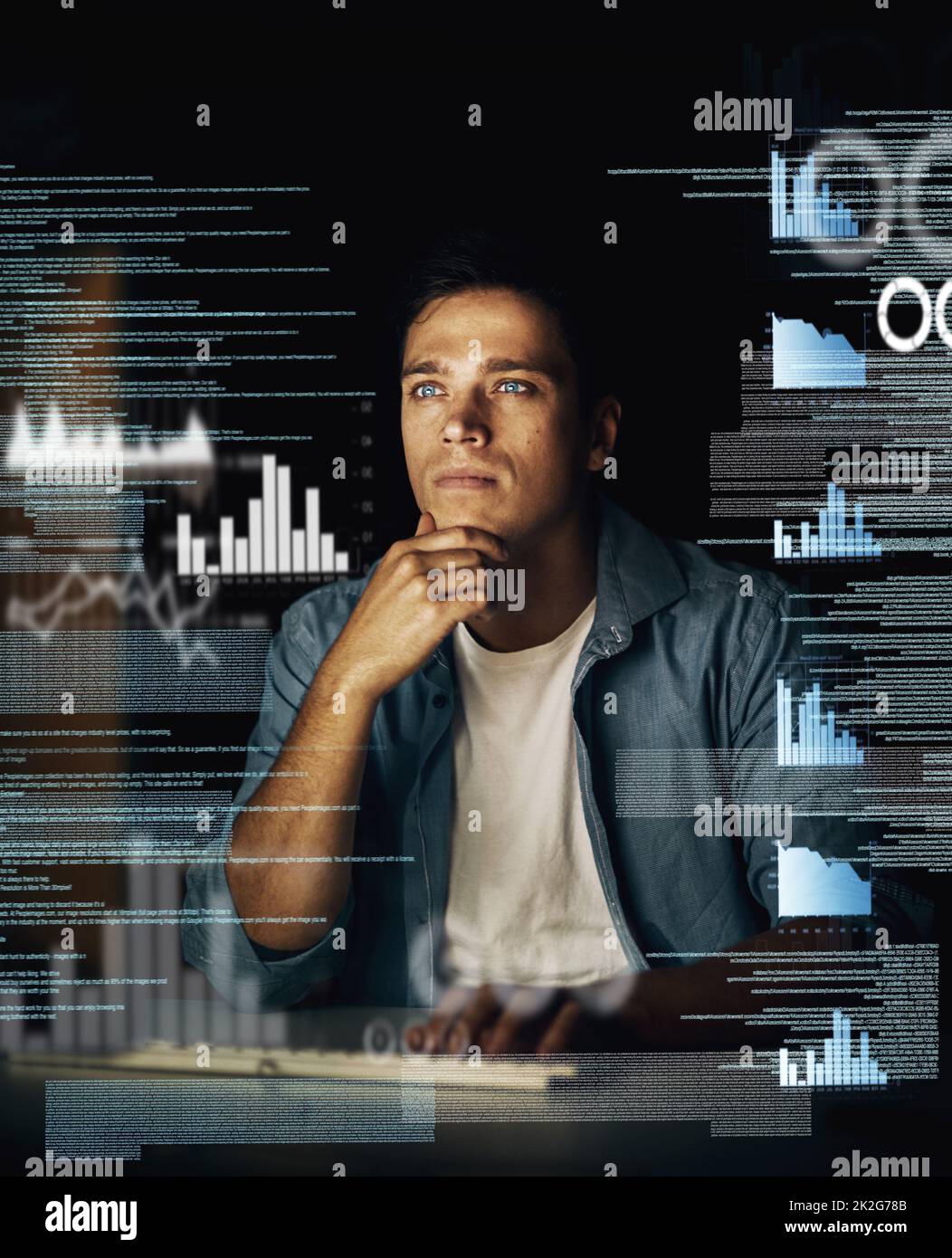 Cracking codes is not just his job but his passion. Cropped shot of a young computer programmer looking through data in the dark. Stock Photo