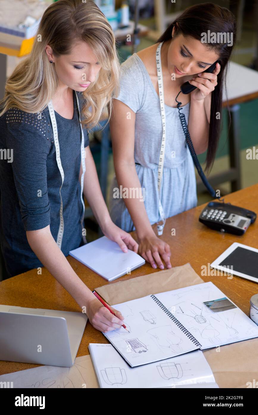 Theyre in demand. Two fashion designers standing at the front counter
