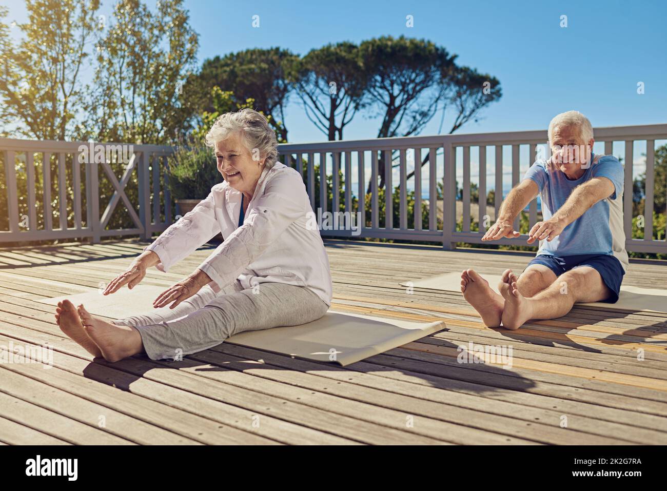 Keeping lithe and limber. Shot of a senior couple doing yoga together on their patio outside. Stock Photo