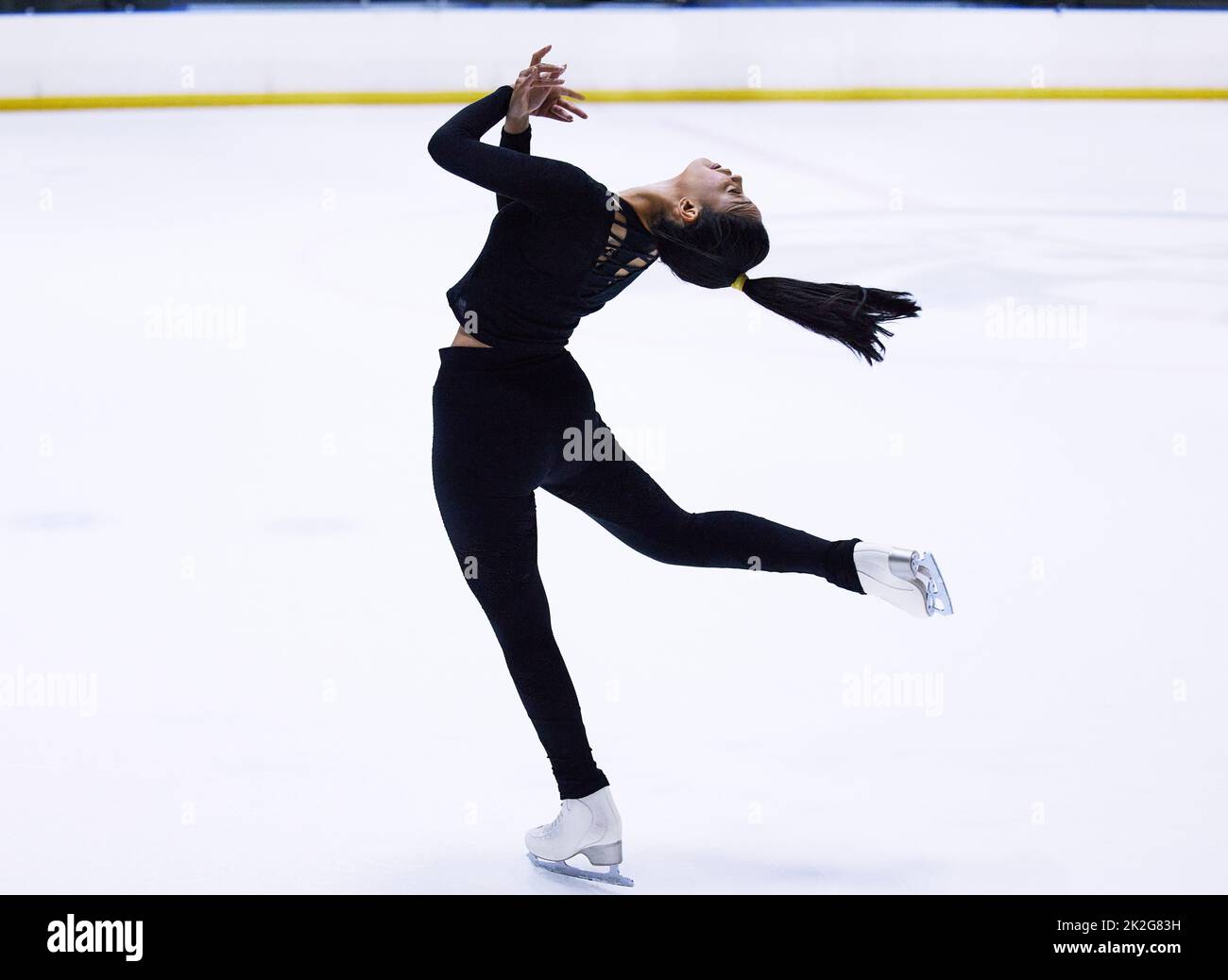 To see her skate is to believe in magic. Shot of a young woman figure skating at a sports arena. Stock Photo