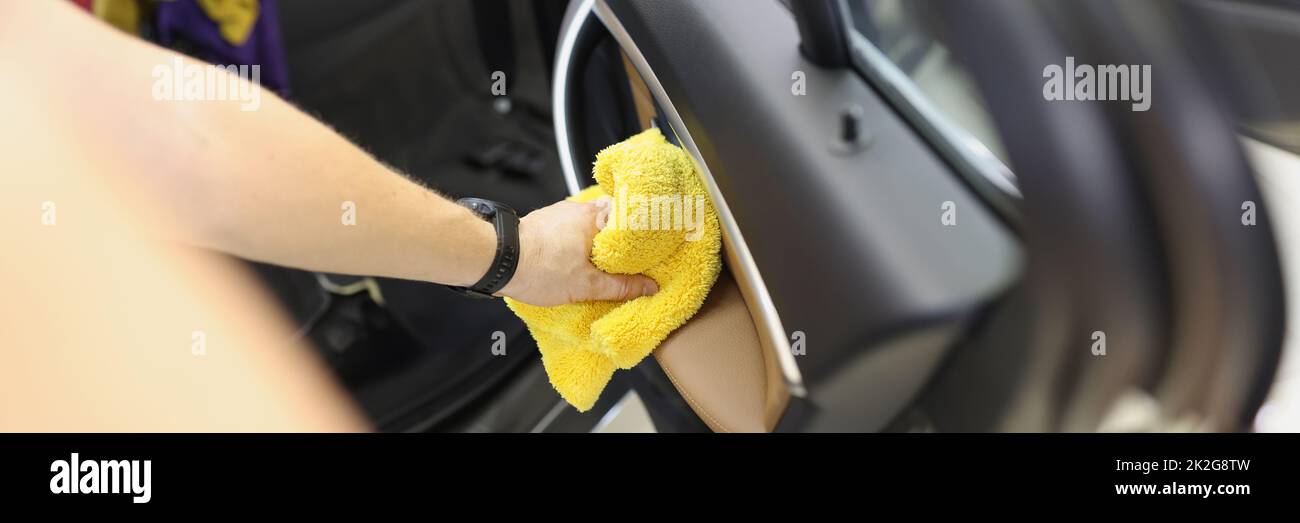 Car cleaner that cleans car door panel with microfiber cloth Stock Photo