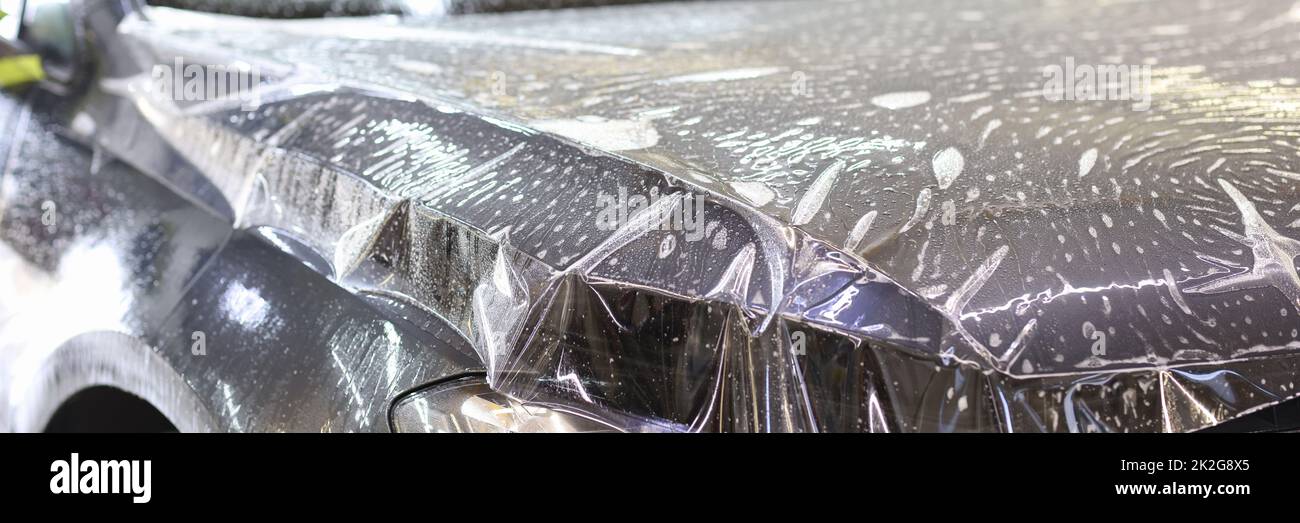 Car wrapping transparent vinyl film. Protection of the car hood from stone chips Stock Photo