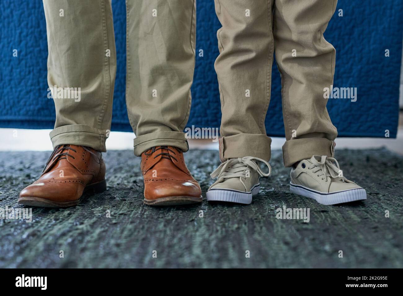 He will fill out Daddys shoes one day. Cropped shot of an unrecognizable man and his son standing side by side. Stock Photo