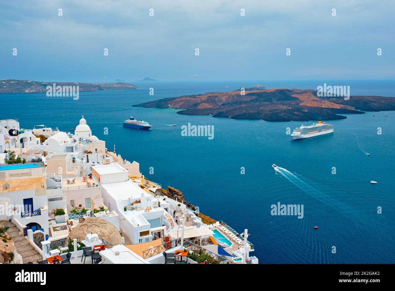 View of Fira town on Santorini island with cruise ships in sea Stock Photo