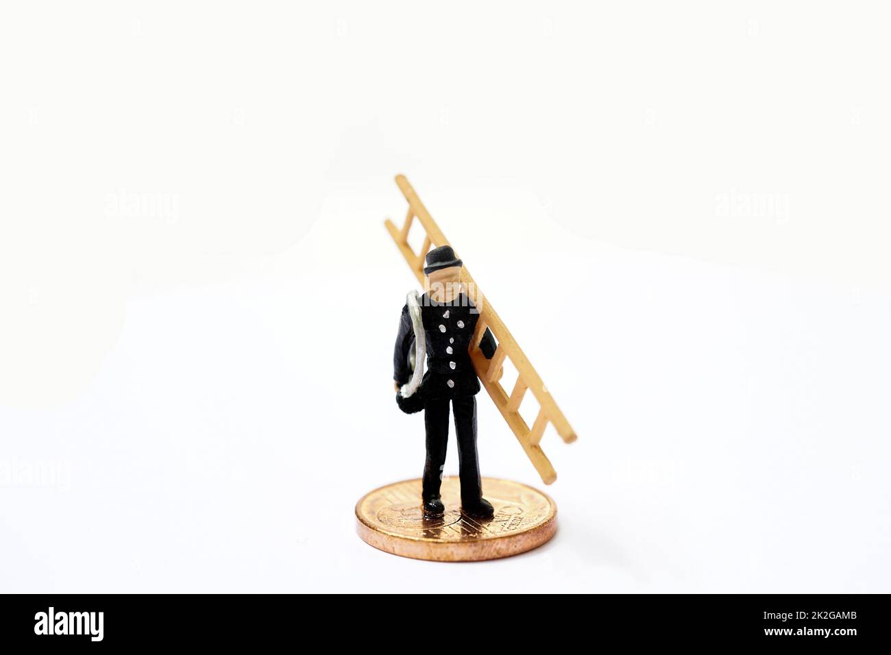 Lucky charm, chimney sweep with ladder stands on coins as a symbol of happiness for prosperity and wealth Stock Photo
