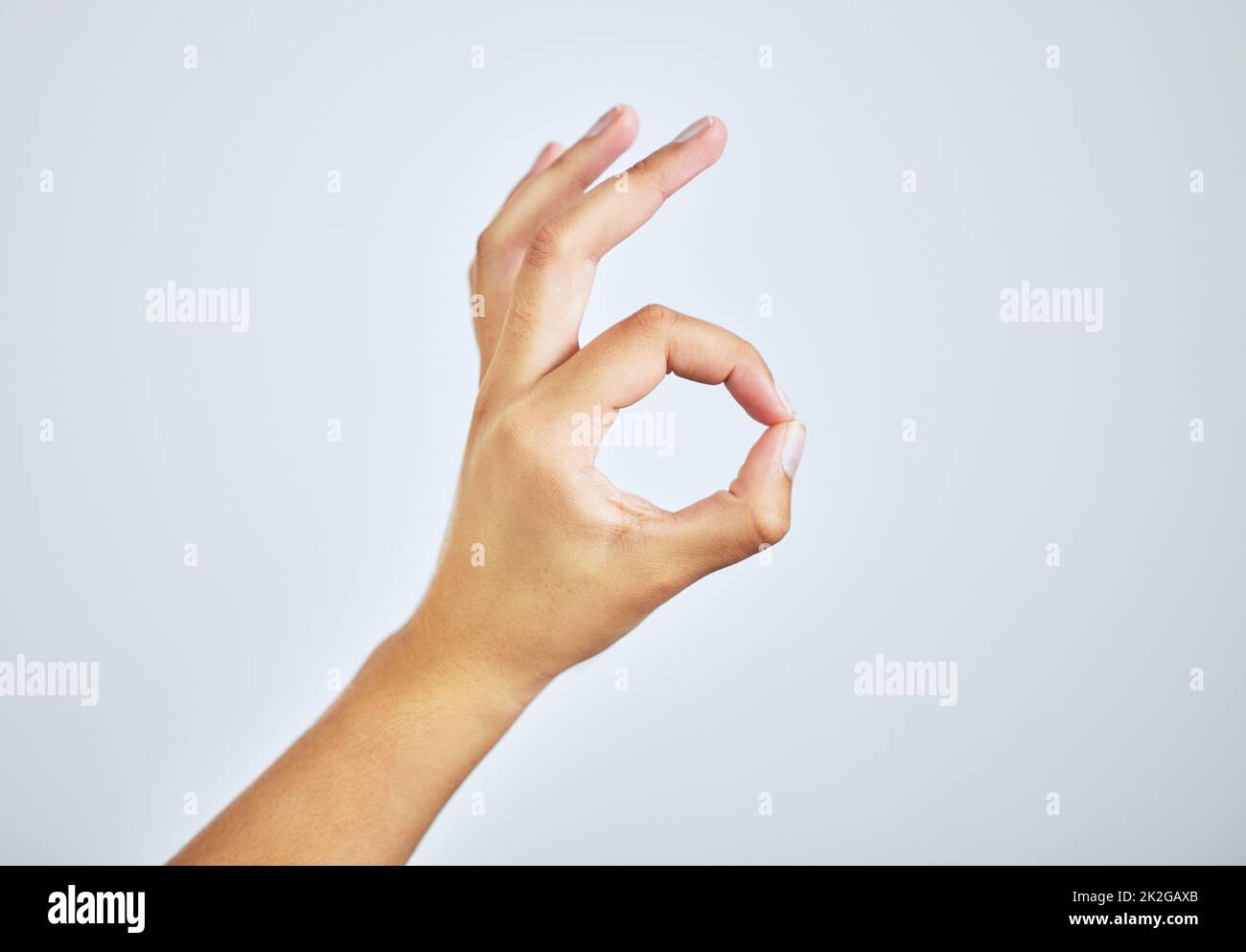 Youre doing just fine. Studio shot of a woman making an a-okay sign with her hand against a grey background. Stock Photo