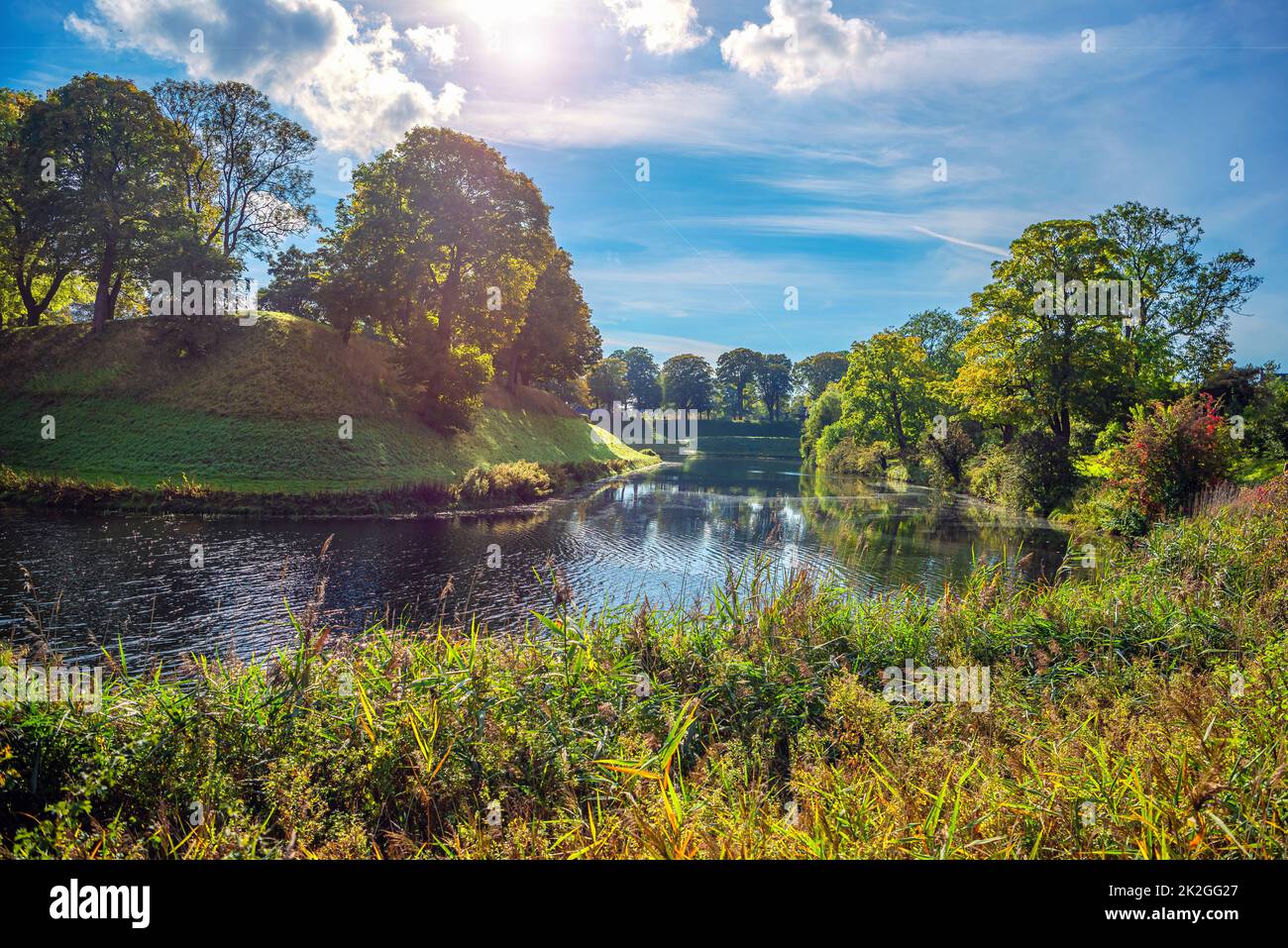 High hills with grass, trees and a river between them in the park that surrounds the fortress citadel Kastellet. Copenhagen, Denmark Stock Photo