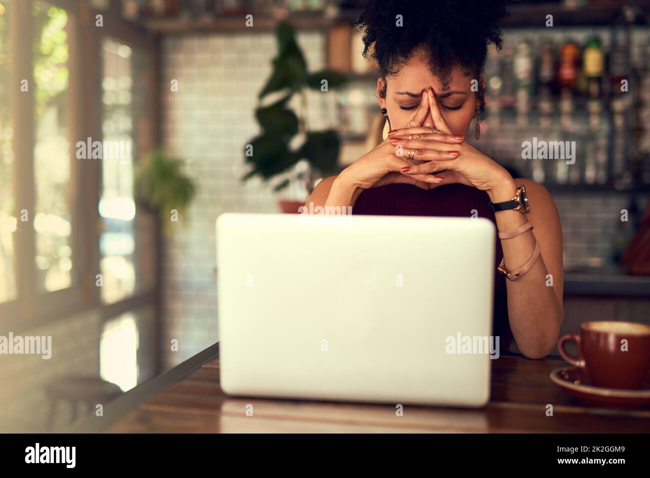 Some things just arent meant to work out. Cropped shot of a young woman looking stressed out while working on her laptop in a cafe. Stock Photo