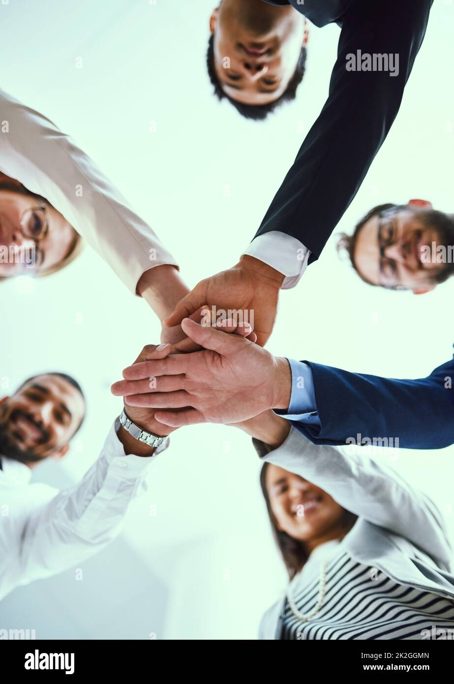 Staying motivated in their quest for success. Low angle shot of a diverse group of businesspeople joining their hands together in unity. Stock Photo