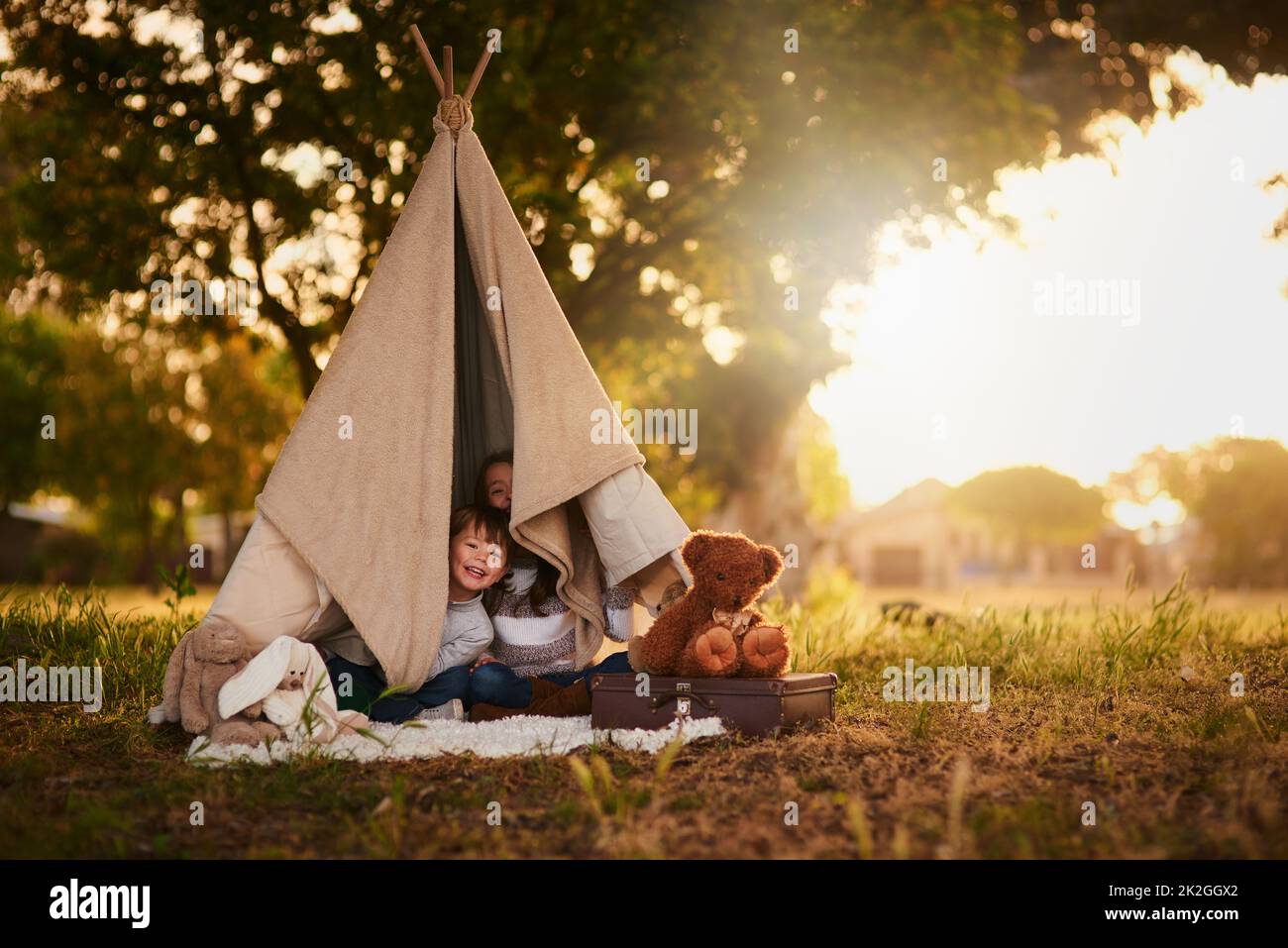 Halt Who goes there. Portrait of two cute little siblings playing together in a teepee outside. Stock Photo