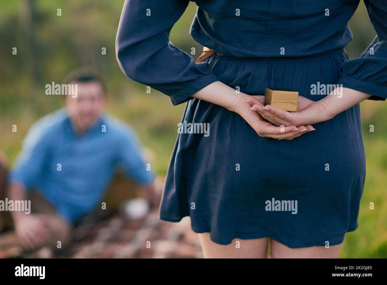 Shes plucked up the courage to pop the question instead. Rear view shot of a woman about to propose to her boyfriend with an engagement ring in a box. Stock Photo