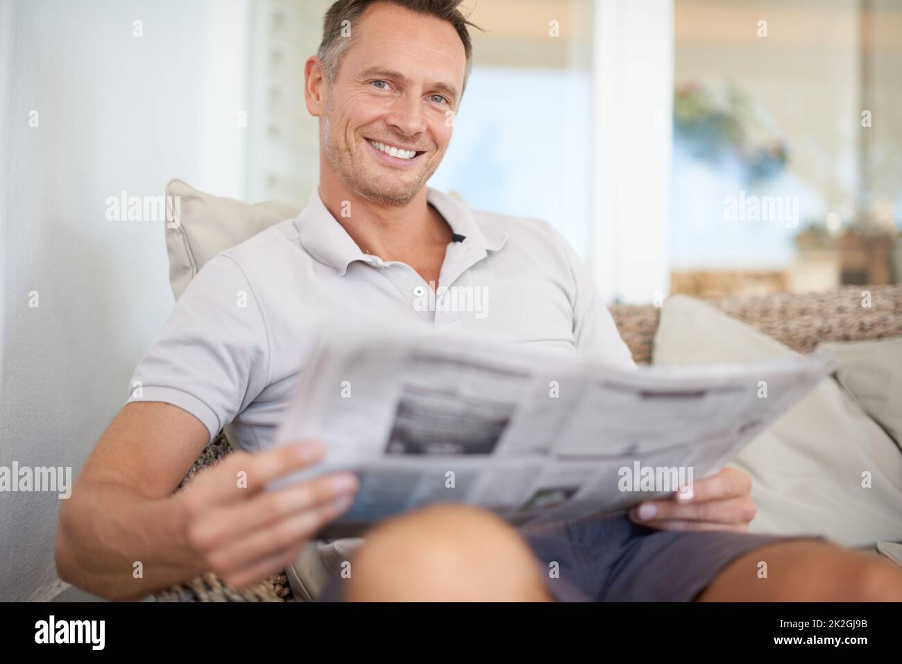The more you read the more youll know, the more you learn more places youll go. A handsome mature man sitting comfortably at home reading the Stock Photo