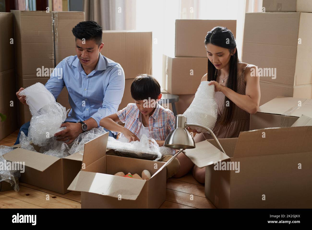 Working together as a family on moving day. Shot of a family packing boxes while moving house
