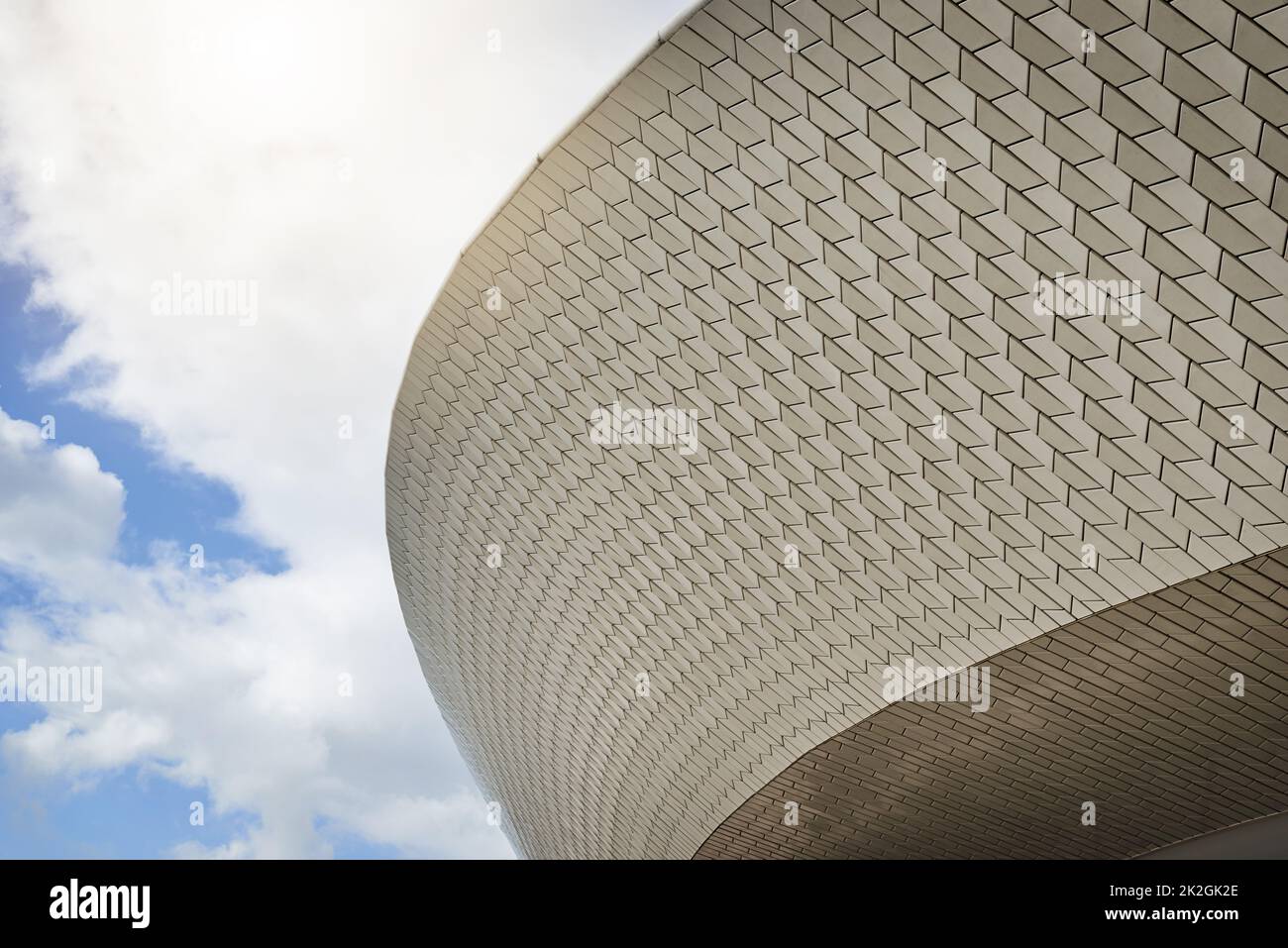 Its a world class stadium. Low angle shot of a sports stadium with clouds in the background outside during the day. Stock Photo