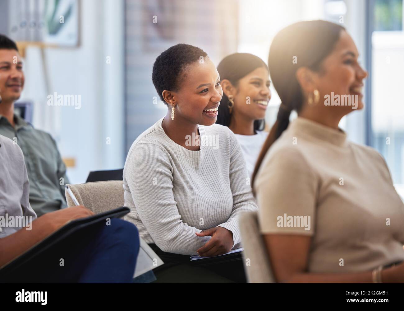 The journey towards success. Shot of a group of employees laughing during a meeting at work in a modern office. Stock Photo