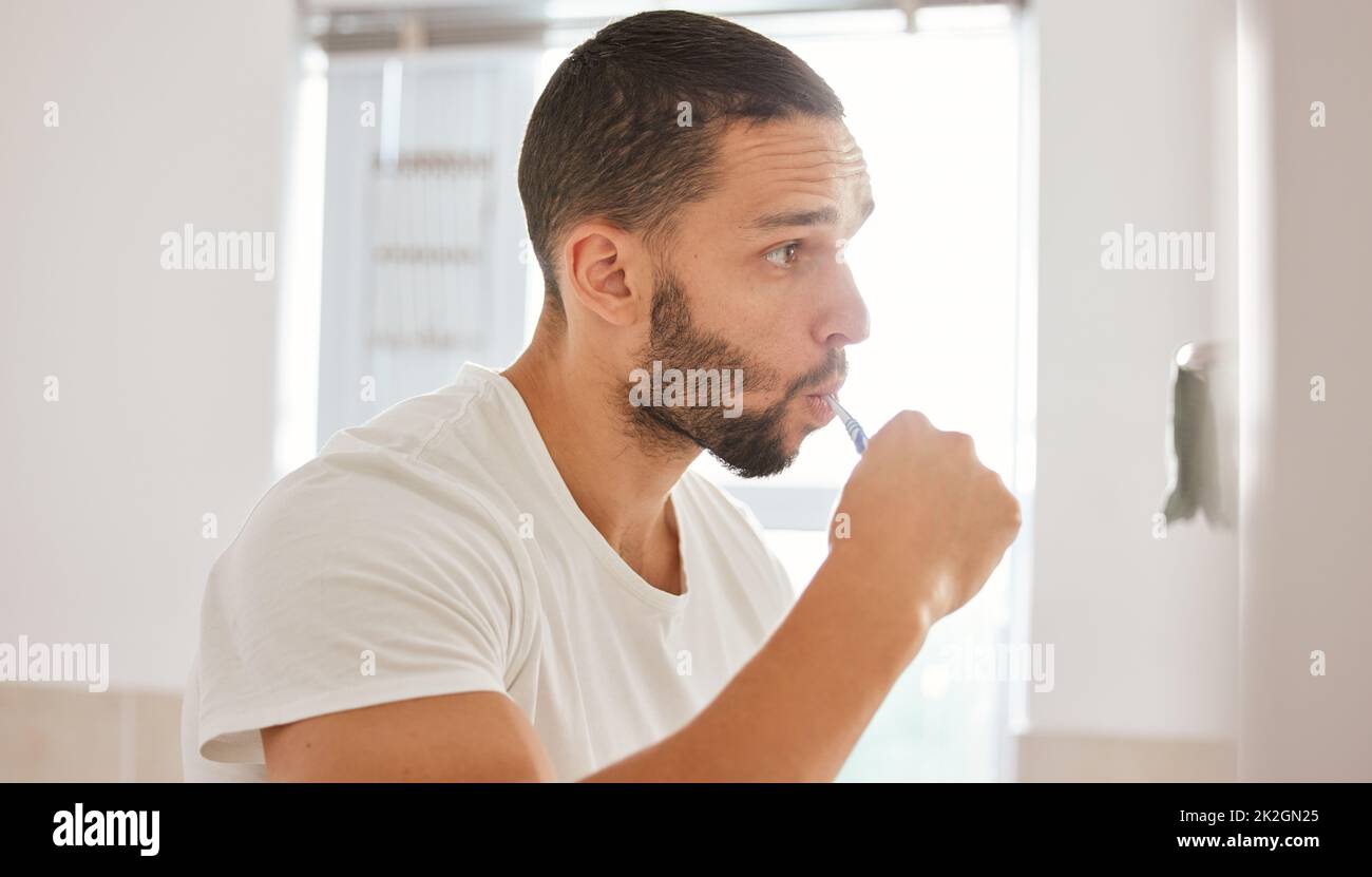 twice-a-day-keeps-the-cavities-away-shot-of-a-young-man-brushing-his