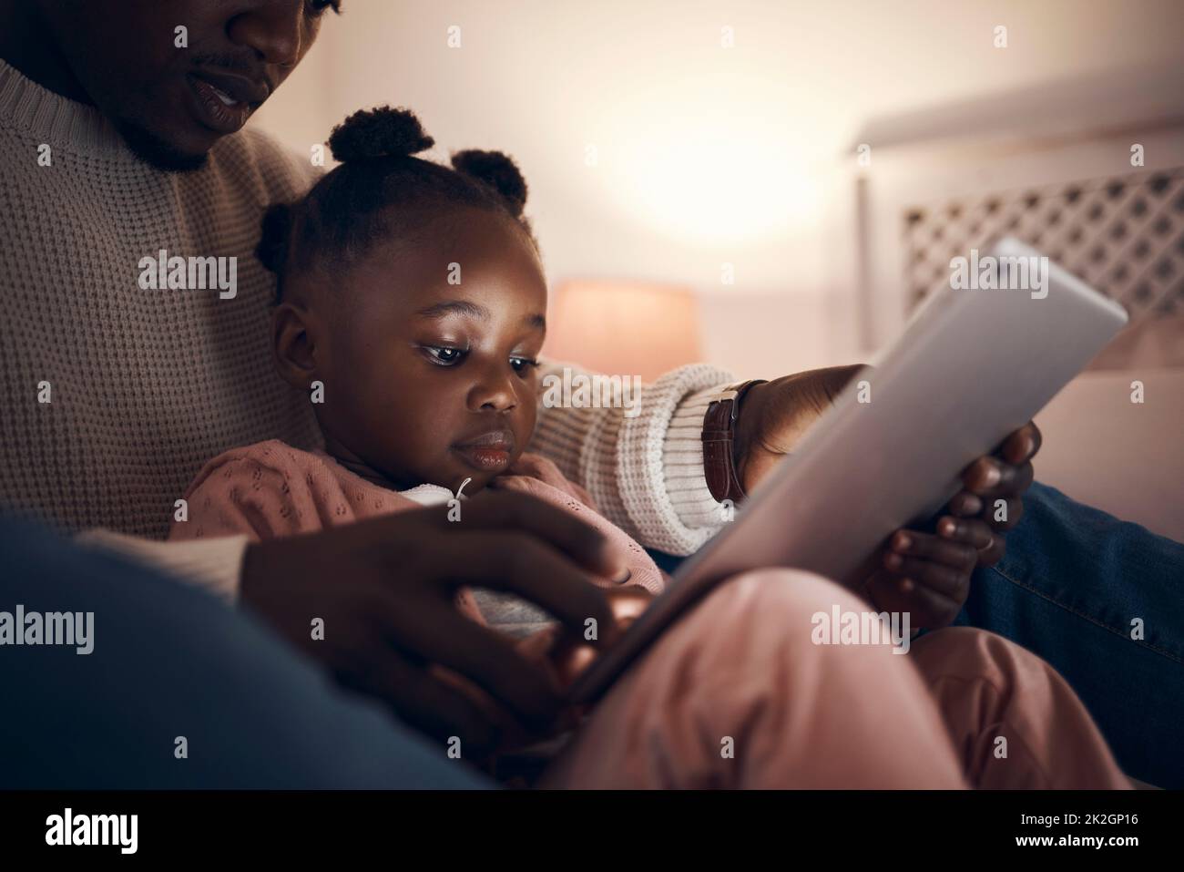 Daddy read me a story please shot of a father reading his daughter