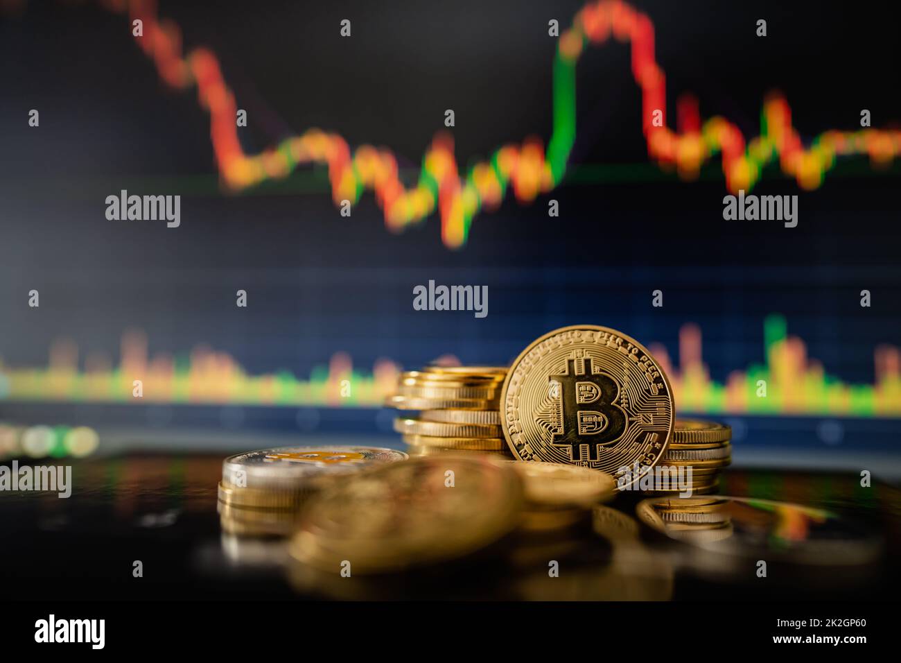 Stack or heap of gold Bitcoins cryptocurrency with candle stick graph chart and digital background. Stock Photo