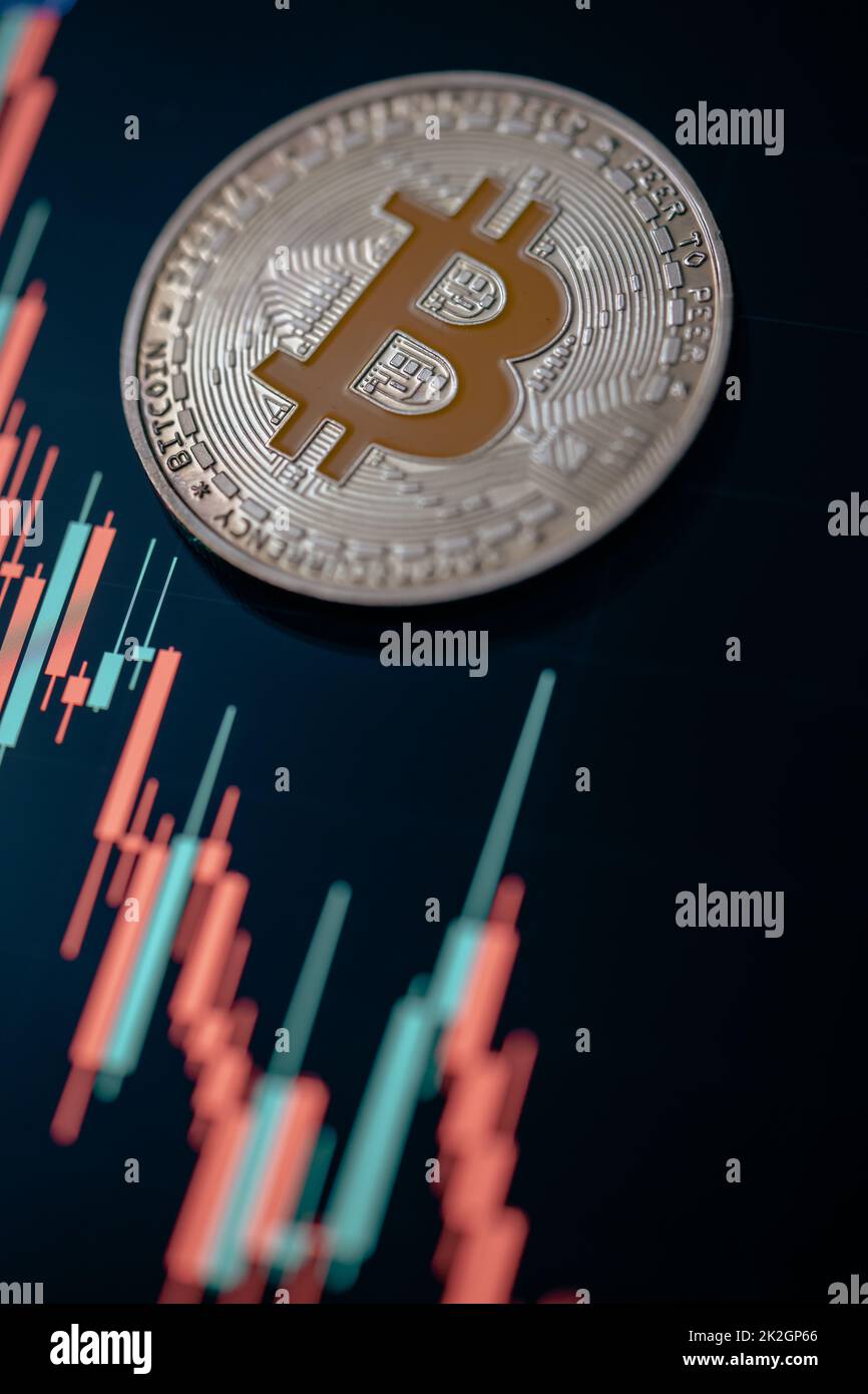 Silver Bitcoin cryptocurrency with candle stick graph chart and digital background. Stock Photo