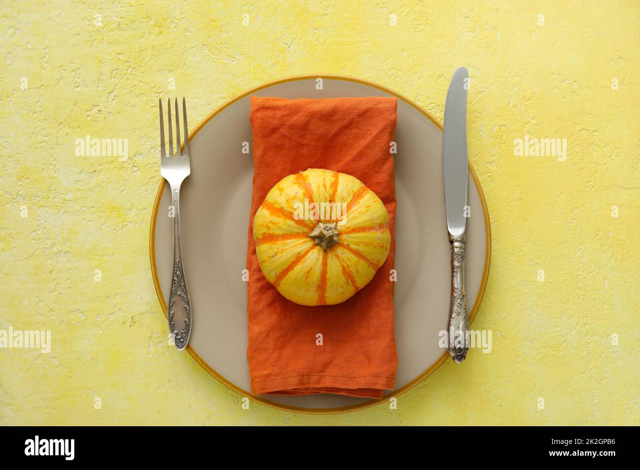 Autumn table setting with fresh pumpkin on yellow background Stock ...