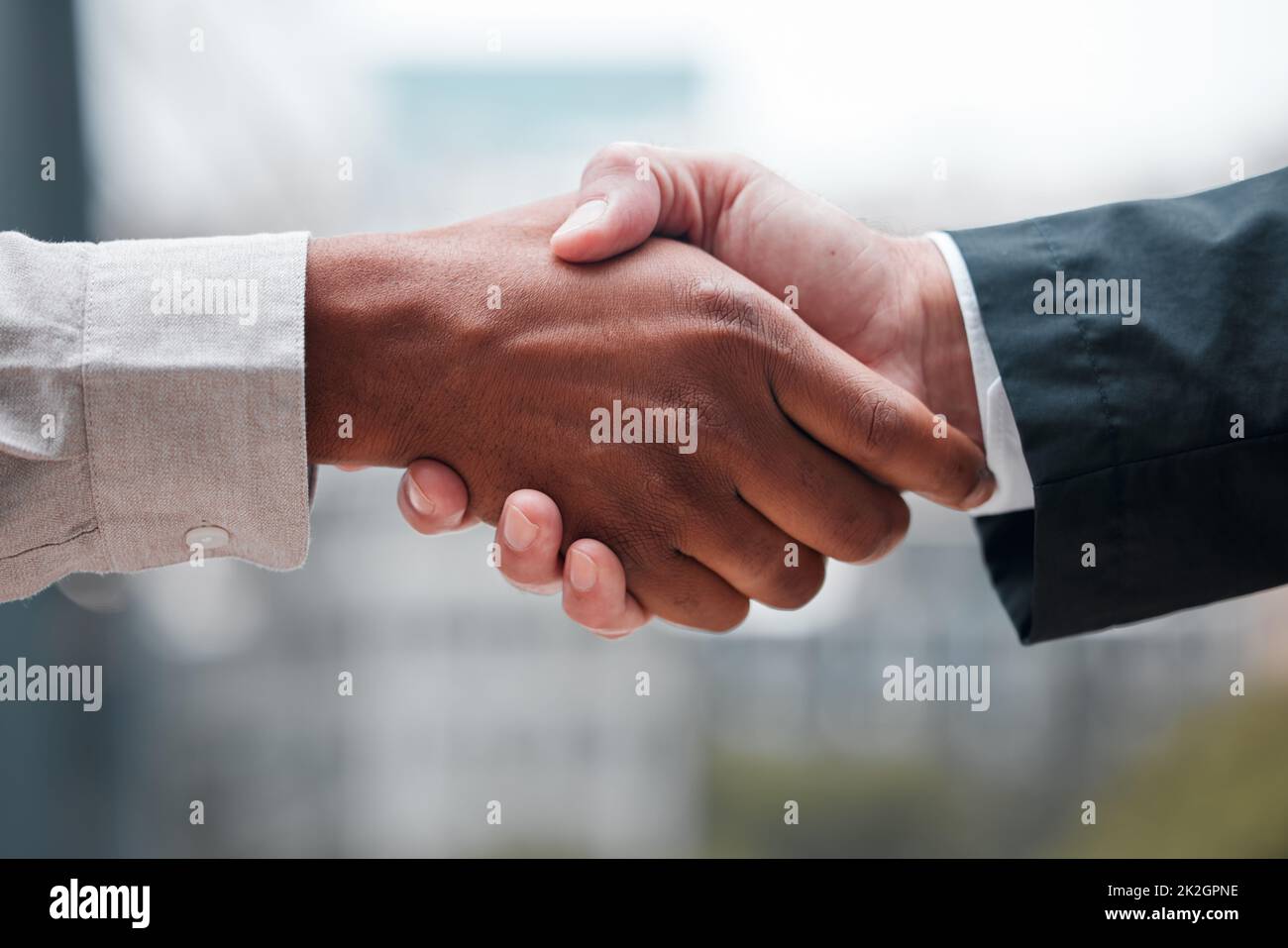 A deal is a deal. Cropped shot of two unrecognizable businessmen shaking hands while standing in their office. Stock Photo