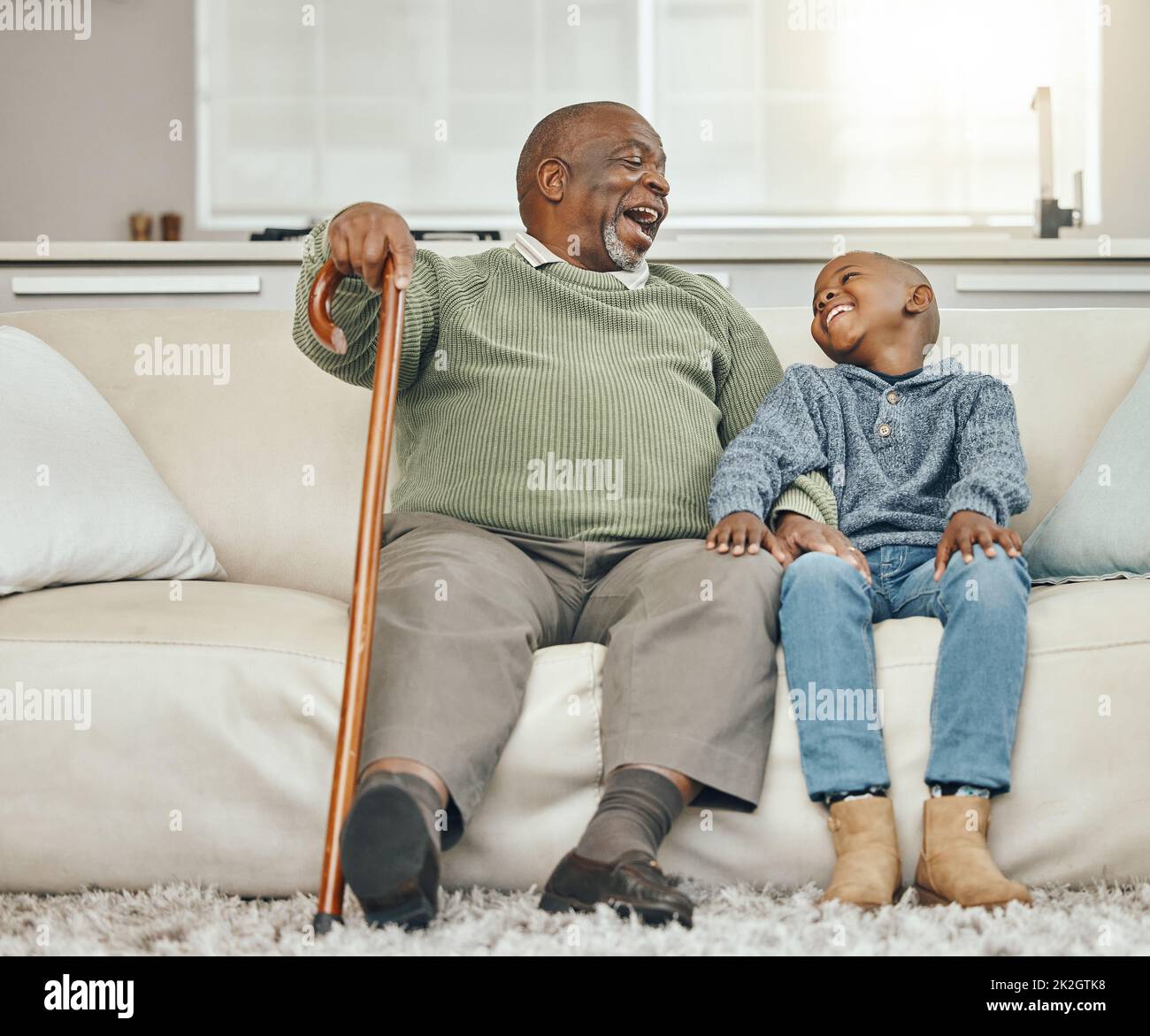 My grandpas the coolest. Shot of a grandfather bonding with his young grandson on a sofa at home. Stock Photo
