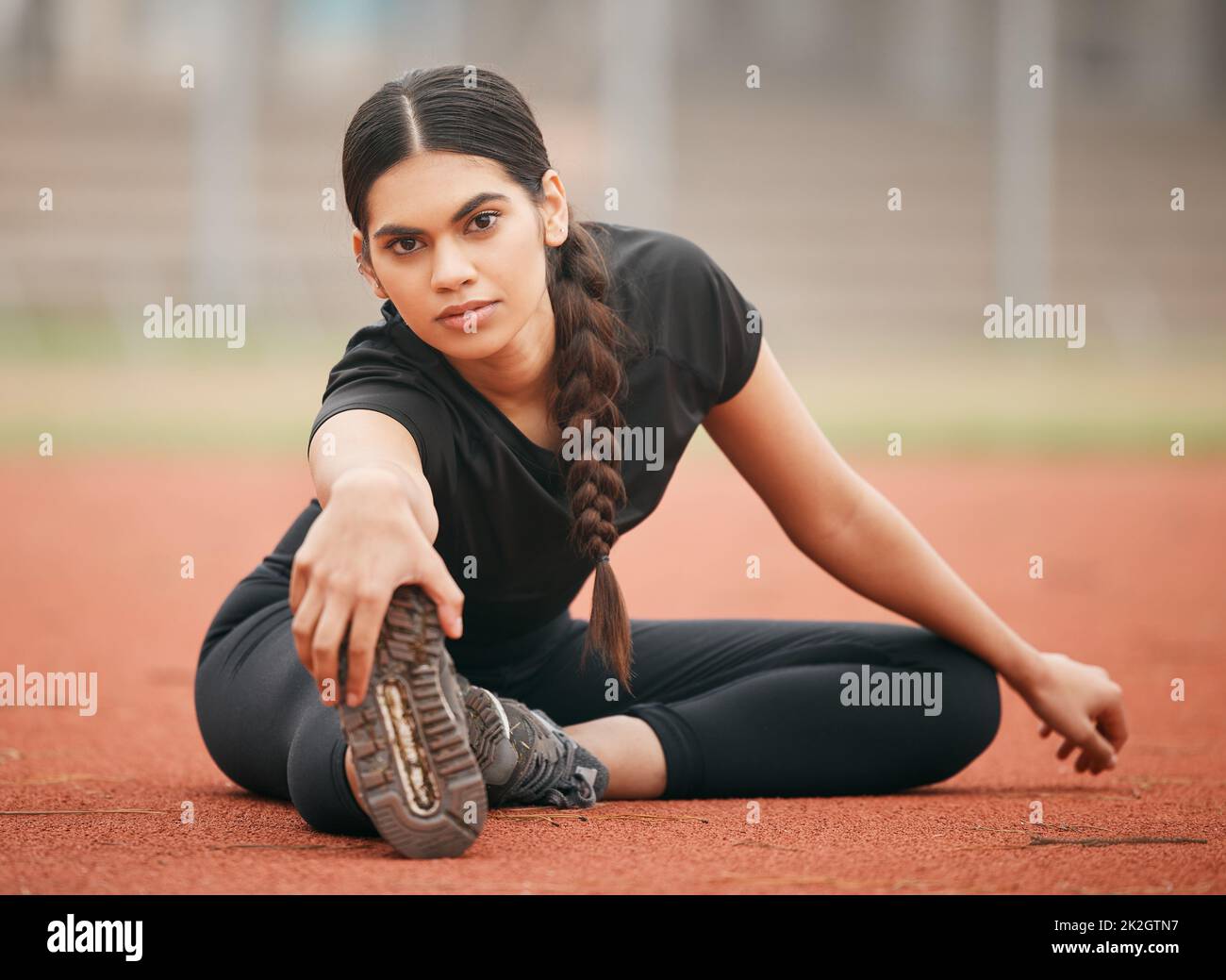 You dont have to be the best, you just have to give your best. Shot of an athletic young woman stretching while out on the track. Stock Photo