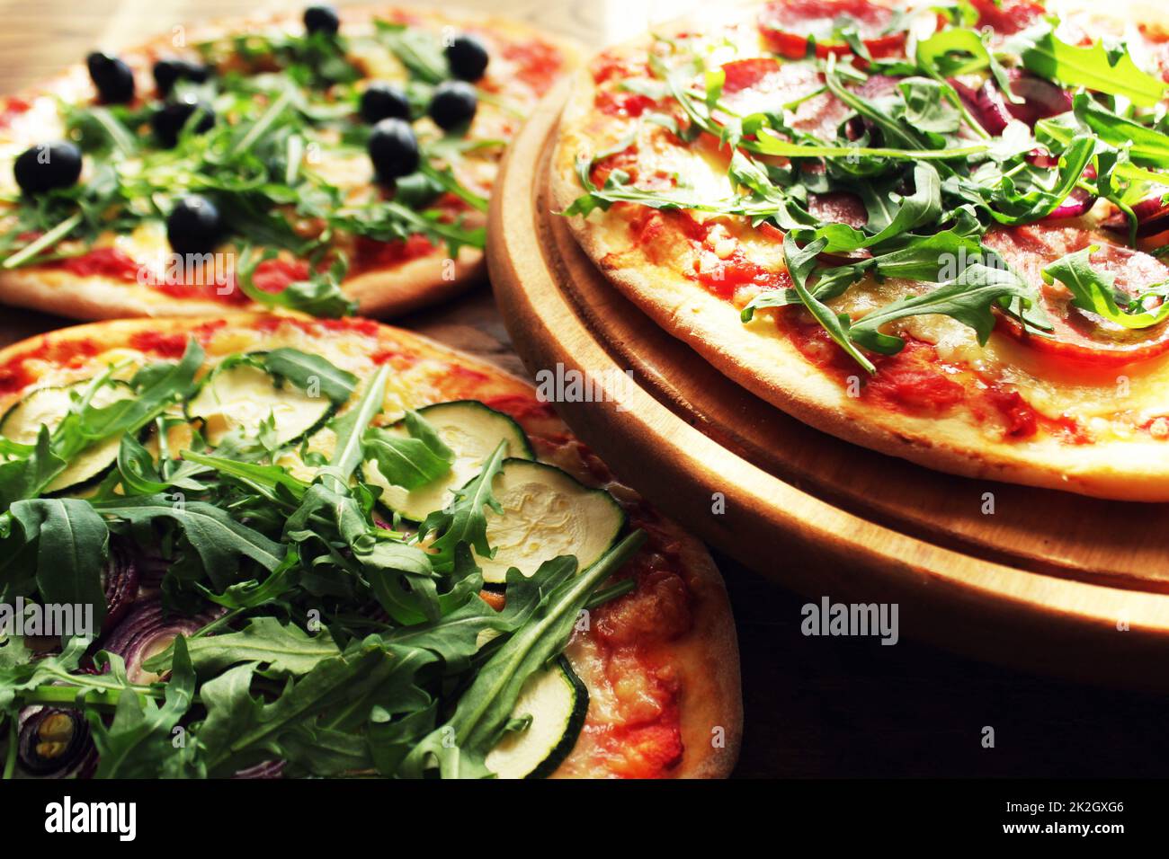 Different variations of pizza.Pizza with sausage, zucchini, olives, cheese rucola. Stock Photo