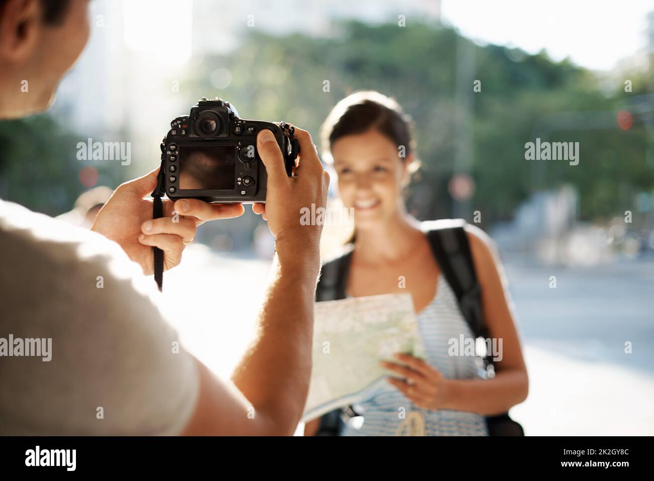 Teasing her with a quick vacation picture. a man taking a photo of his girlfriend while theyre touring a foreign city. Stock Photo