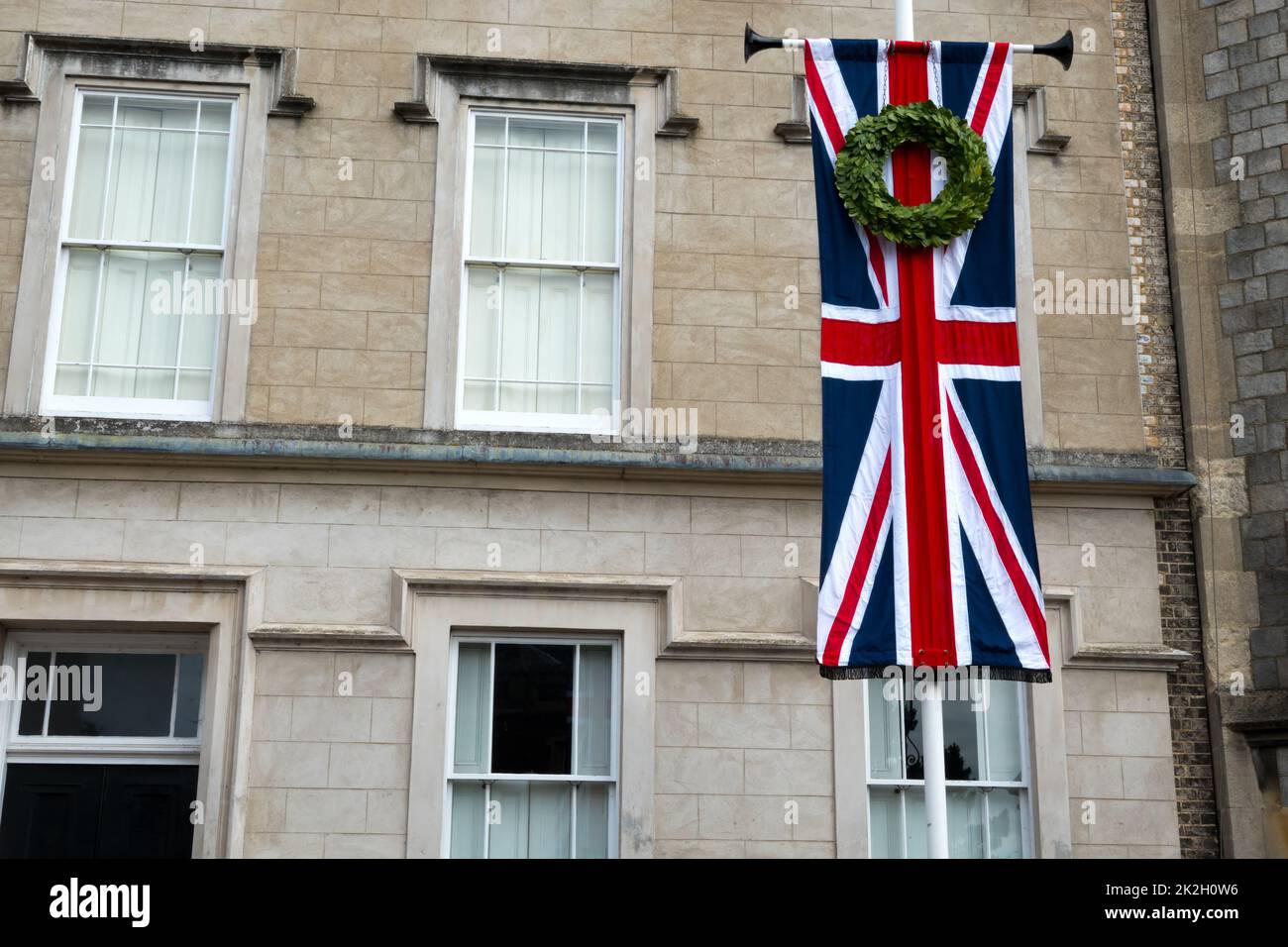 Union Jack flag with a floral wreath hanging at a house close to Windsor Castle on the death of Elizabeth II Stock Photo