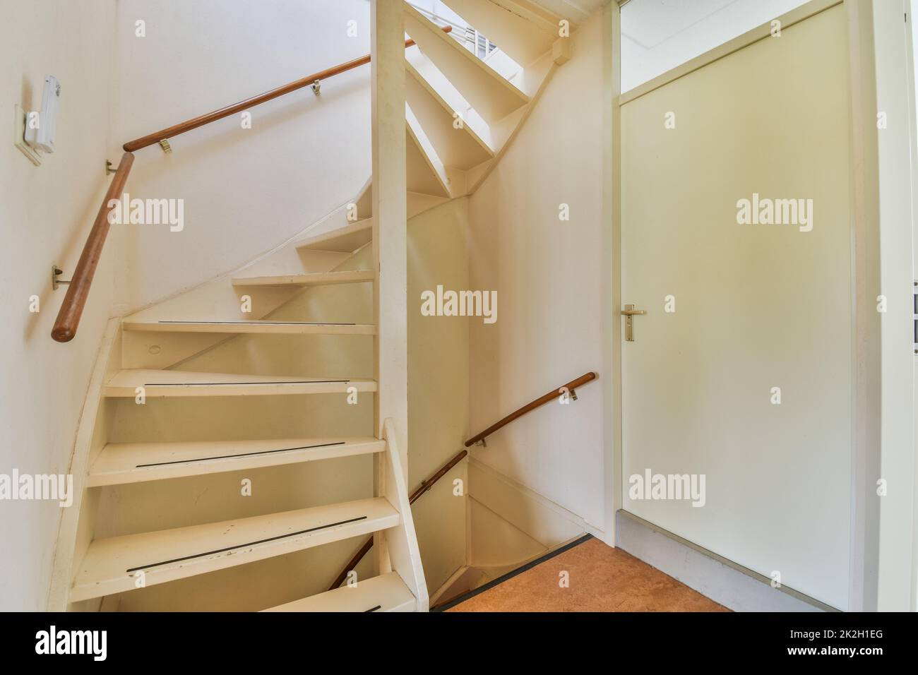 Staircase and elevator located near door and brick wall in hall of