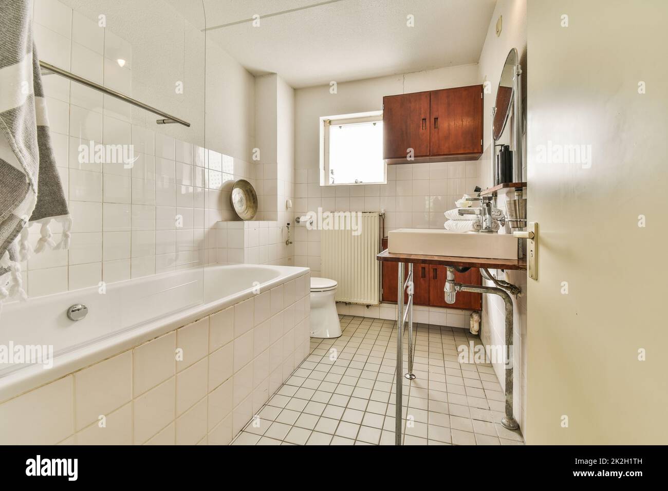 Glass partition between shower tap and wall flush toilet in barhroom at