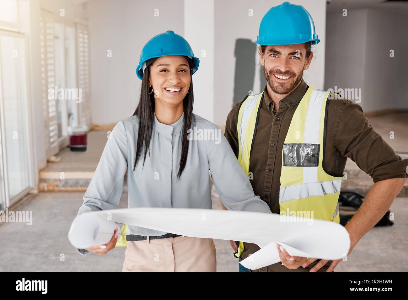 Building the house weve always dreamt of. Shot of two young architects looking at building plans on site. Stock Photo