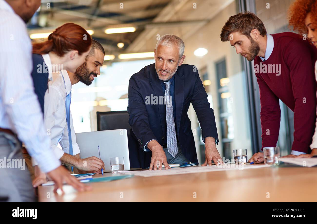 Going over the details of their business plan. Shot of a group of businesspeople working together in an office. Stock Photo