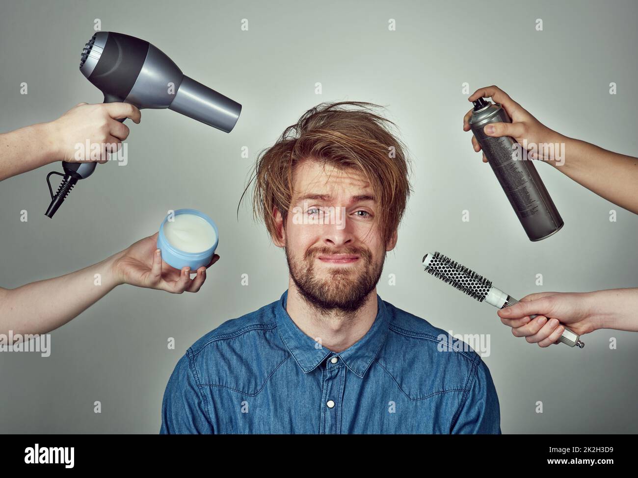 Theres no excuse for not looking your best. Studio portrait of a young man getting a hair makeover against a gray background. Stock Photo