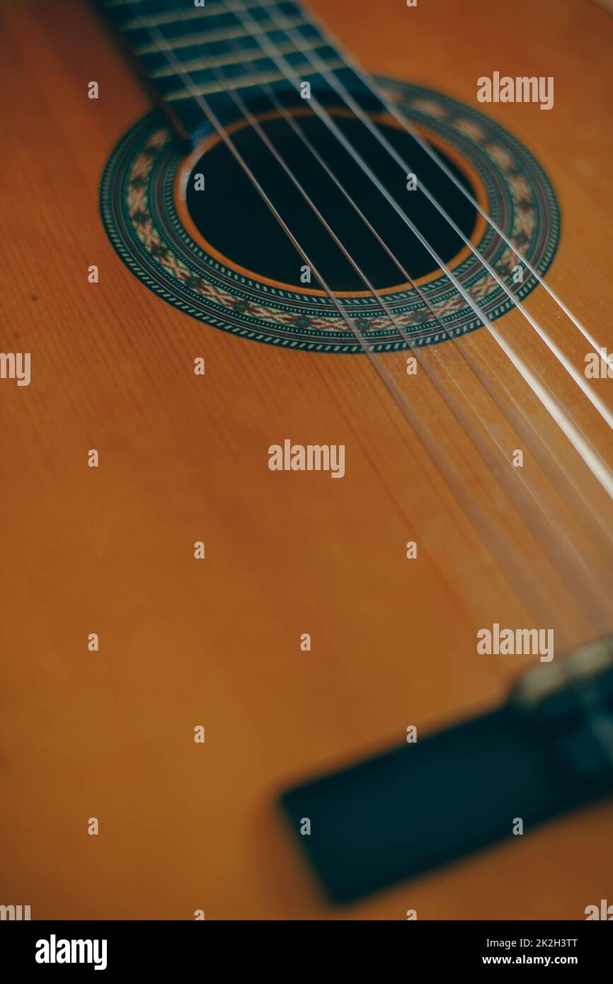 Close up shot of a wooden classical guitar, with plastic strings. Stock Photo