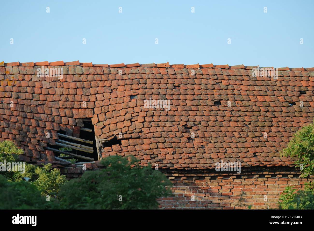 Dilapidated tiled roof of a barn Stock Photo