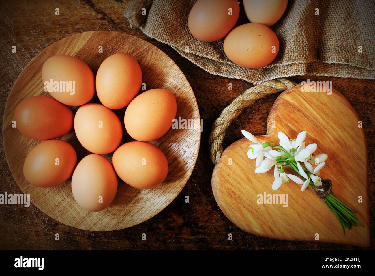 Easter background. Rustic wooden table with plate, egg, flowers and ...